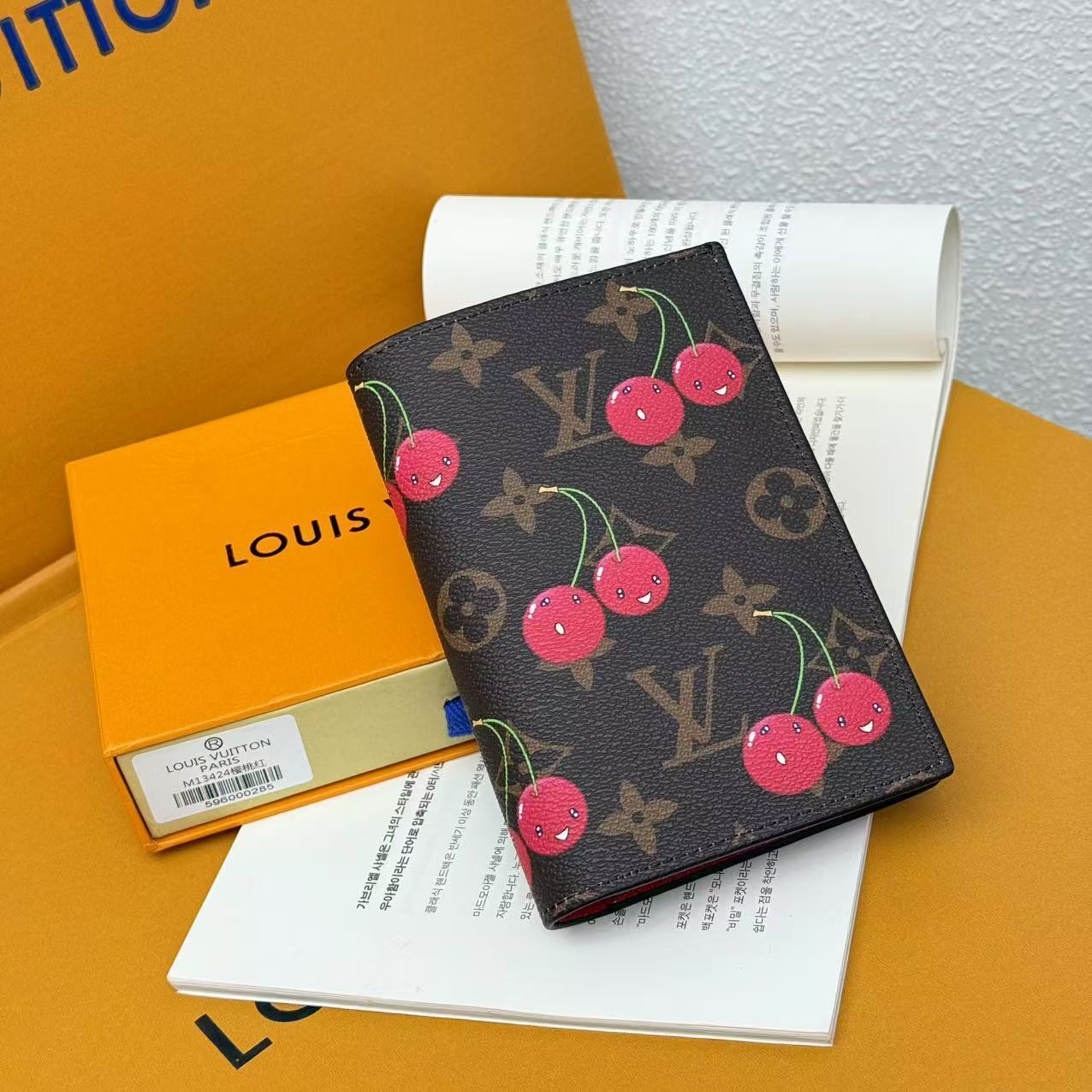 Cherry print monogram passport cover styled with feminine travel essentials
